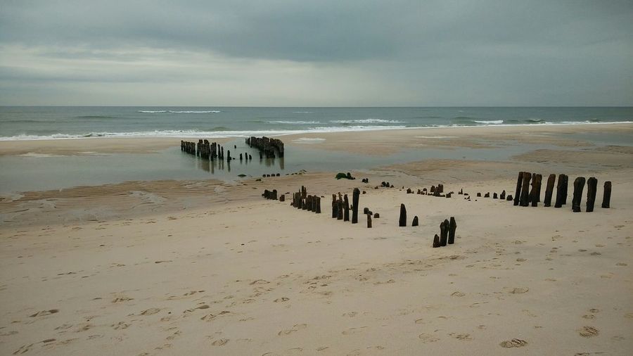 Panoramic view of people on beach against sky