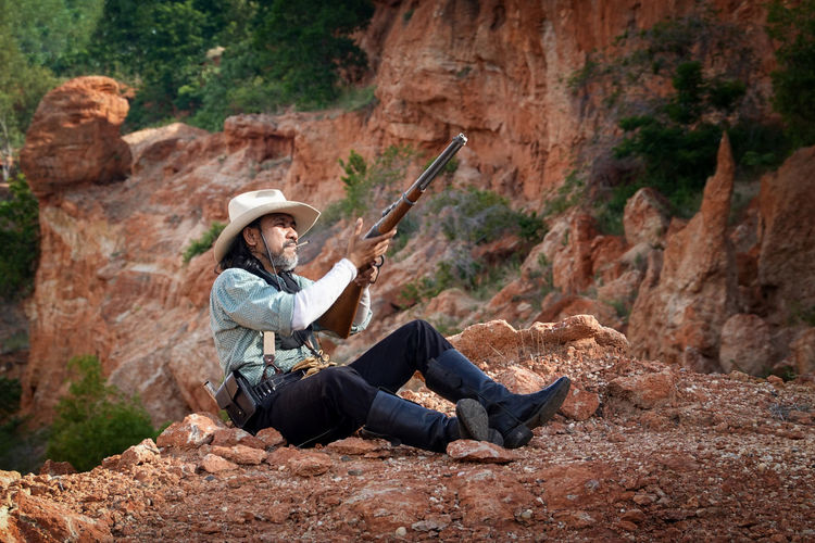 A cowboy man sitting and resting to smoke to relax