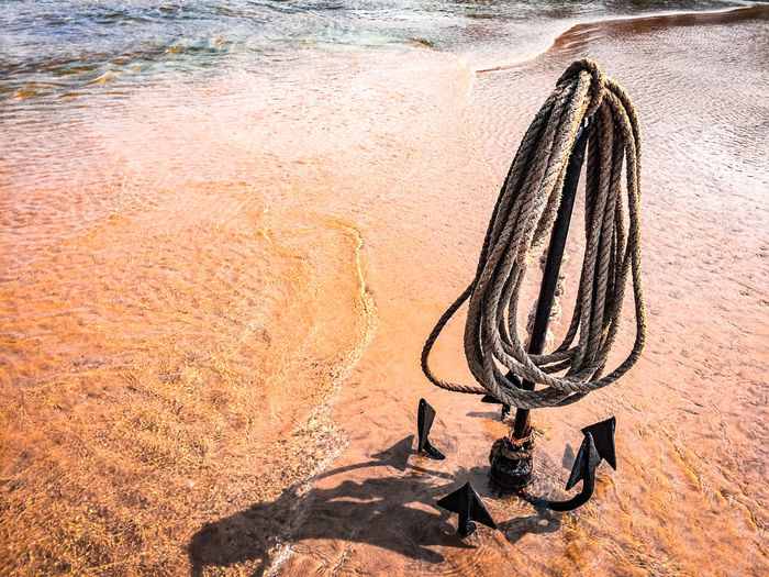 High angle view of rusty anchor on beach 