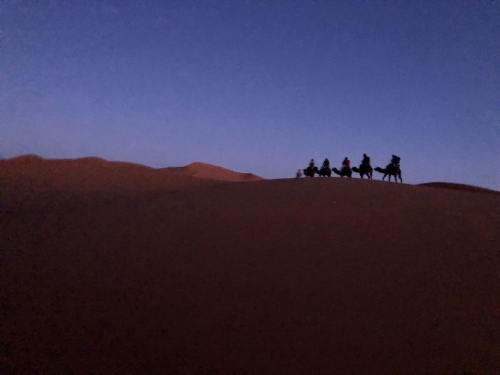 Group of people on desert against clear sky