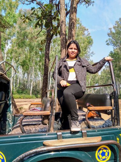 Portrait of young woman standing in jeep