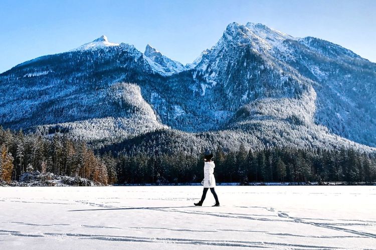 Full length of person on snow covered field against mountain