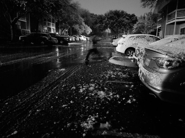 Cars on wet street against sky