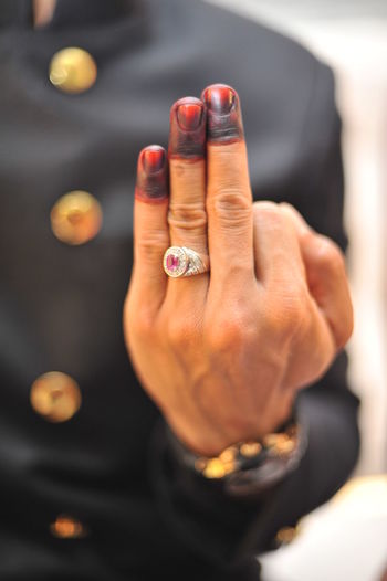 Cropped image of man with henna tattoo wearing wedding ring