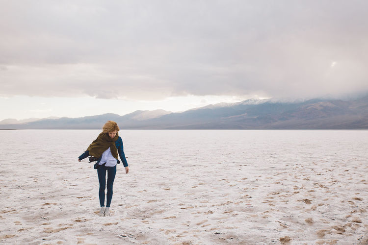 Young woman standing at death valley national park against cloudy sky