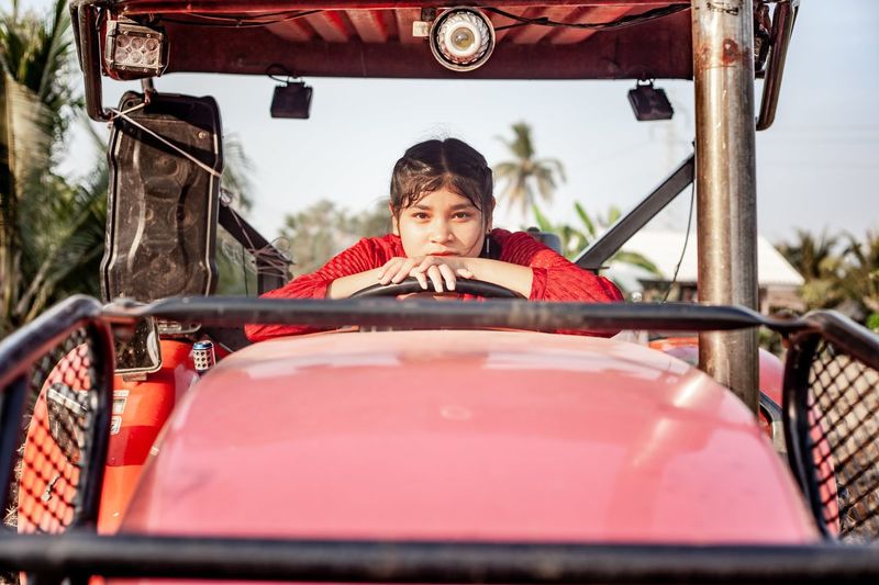 Portrait of happiness pretty beautiful chubby girl with red dress posing with vintage car.