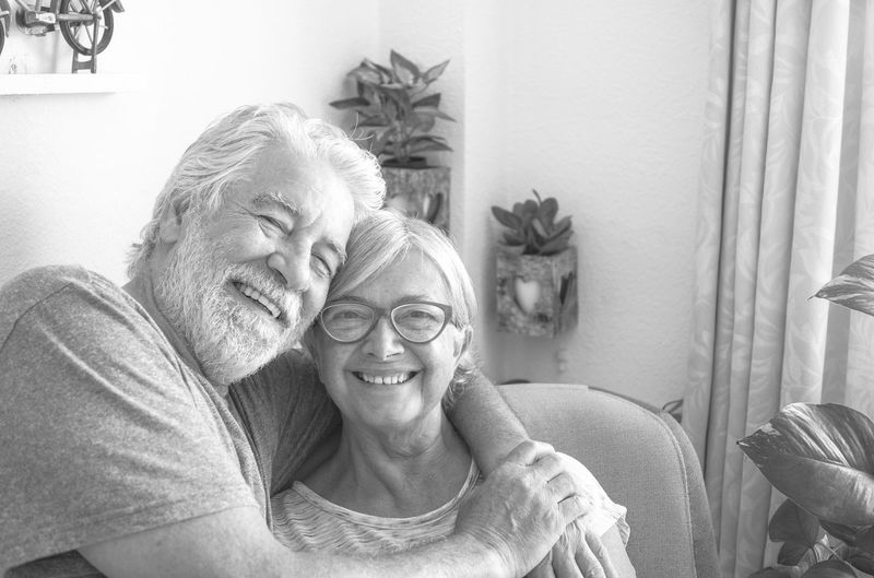 Portrait of senior couple embracing sitting at home