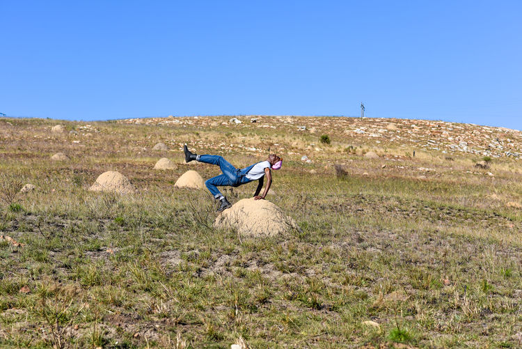 Young man seen stretching in nature with hills in background
