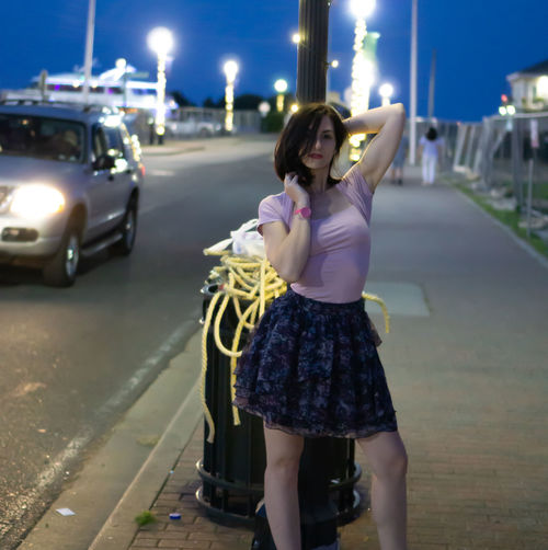 Full length of woman standing on road at night