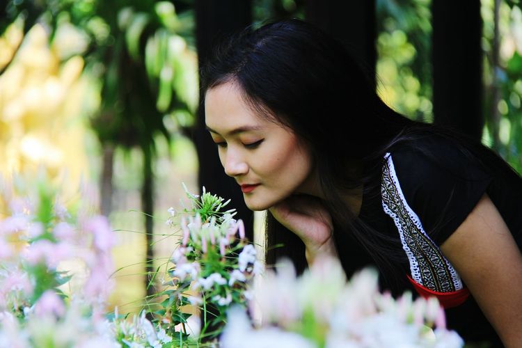 Beautiful woman smelling flowers