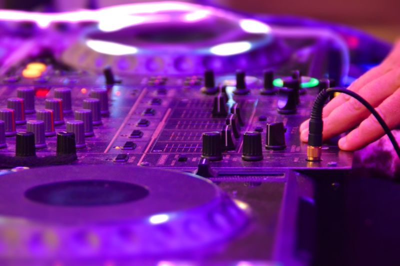 Cropped hand of dj operating sound mixer