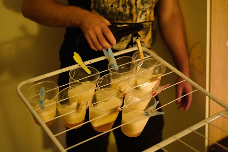 Midsection of man carrying beer glasses in rack