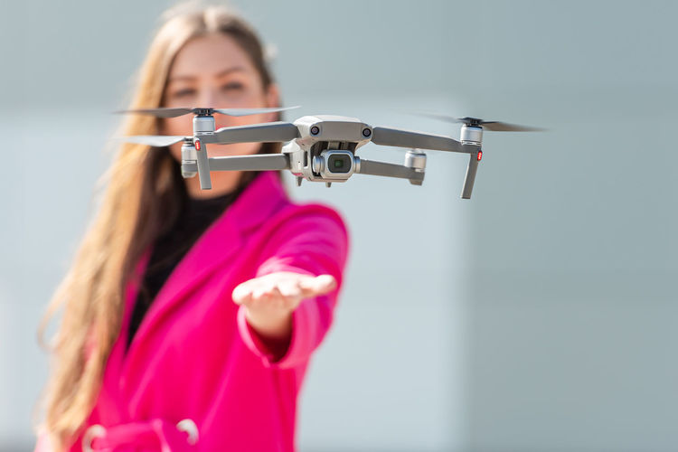 Close-up of drone while woman standing in background