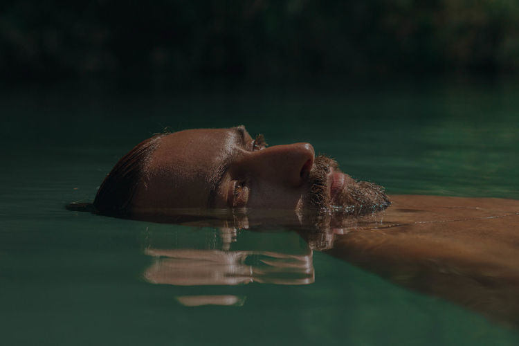 Close-up of man floating on water
