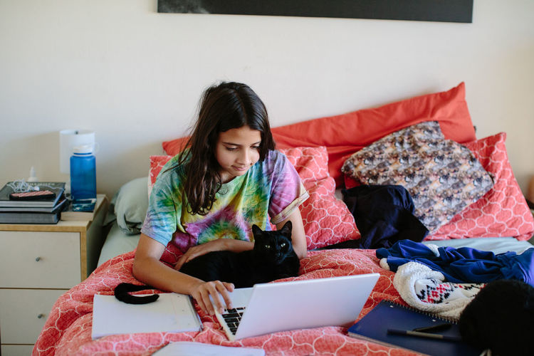 Middle school girl works on her laptop for school during quarantine