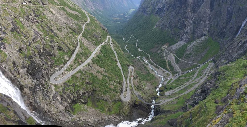 High angle view of winding roads and stream on mountains