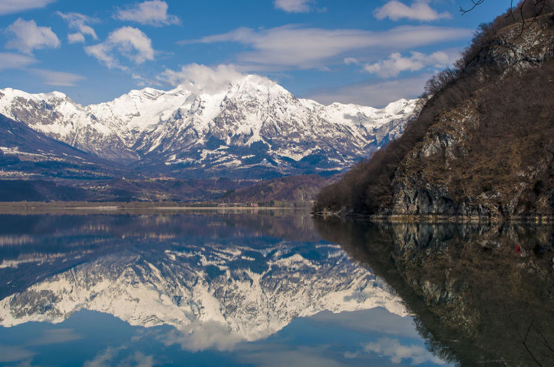 Reflection of snow covered mountains on calm lake