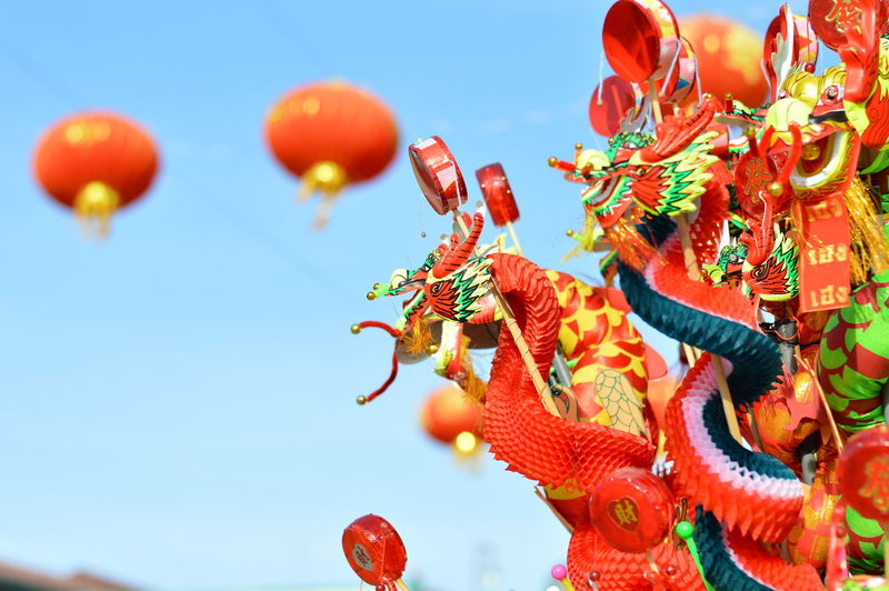 Close-up of chinese dragon paper doll at store against clear blue sky
