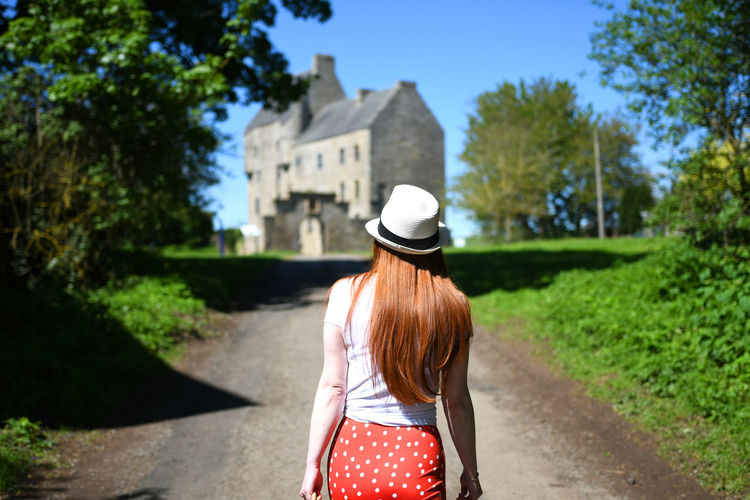Rear view of woman walking on road