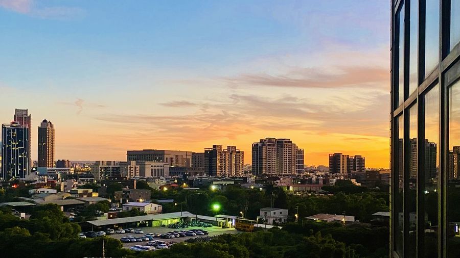 Buildings in city against sky during sunset