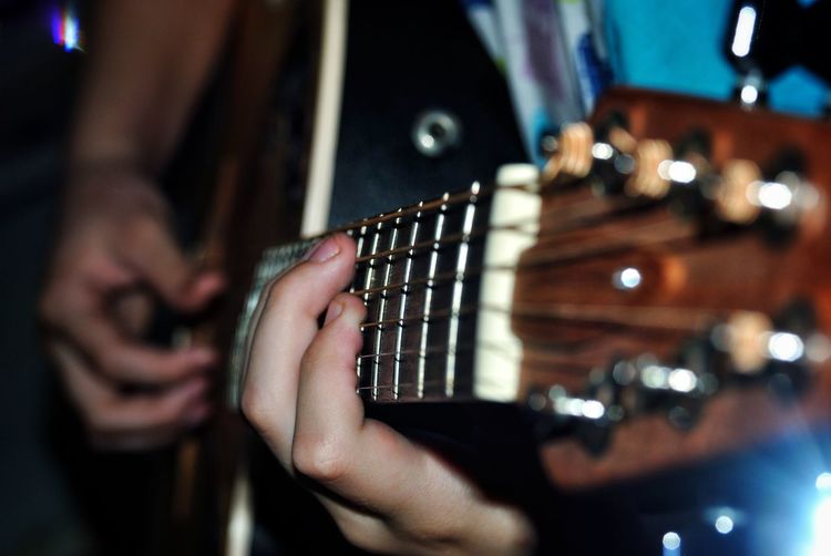Close-up midsection of man playing guitar