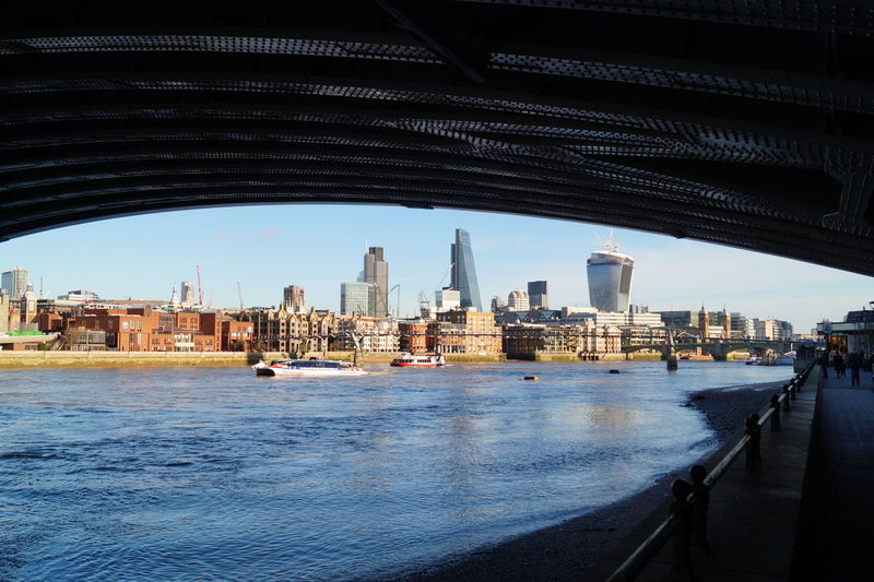View of bridge over river by buildings in city