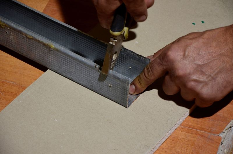Cropped hands using pliers on metal in workshop