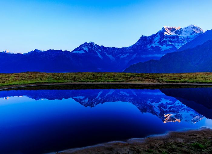 Reflection of mountains in lake against blue sky
