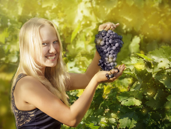 Young woman holding grapes