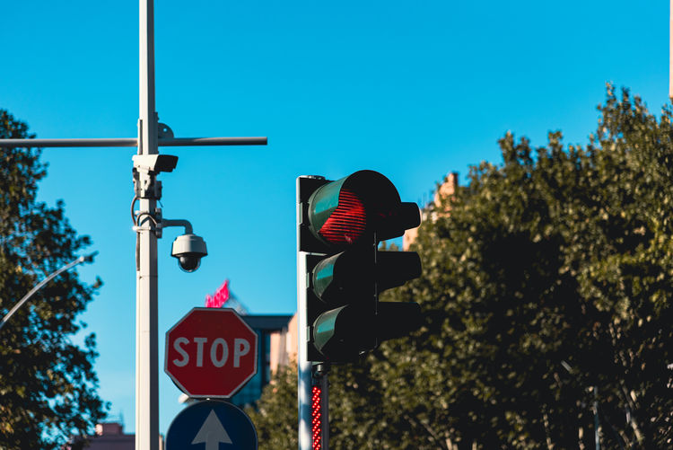 Low angle view of road sign against blue sky