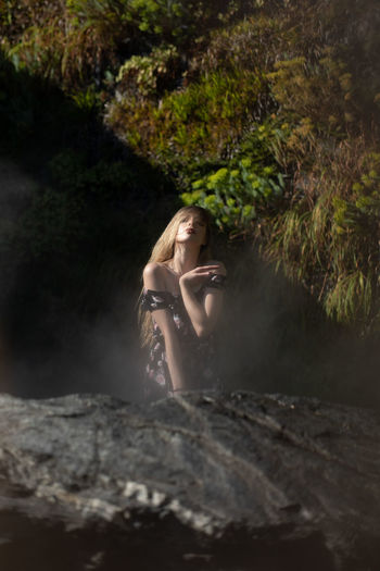Woman sitting on rock in forest