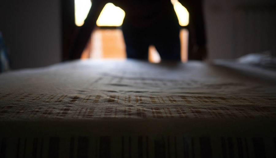 Low section of person standing on bed