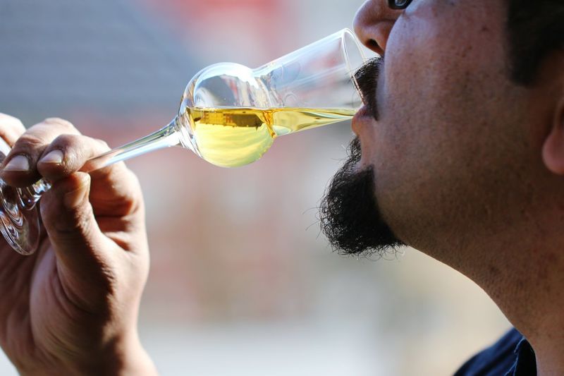 Cropped image of man drinking white wine