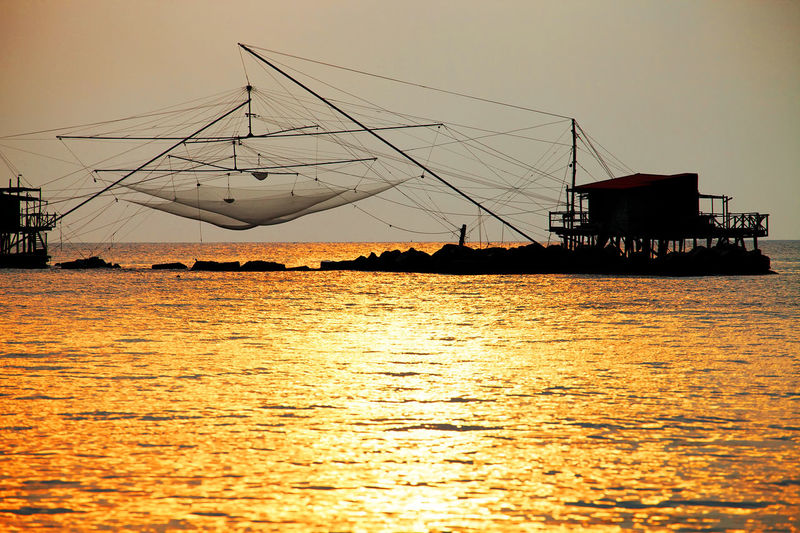 Fishing nets on sea during sunset