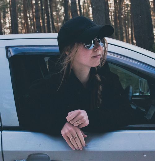 Young woman looking through window in car