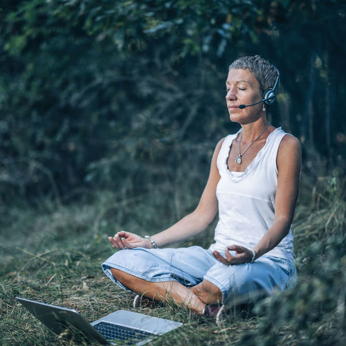 Online meditation. personal development trainer meditating with her clients over the internet