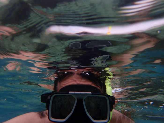 Close-up of man wearing scuba mask swimming