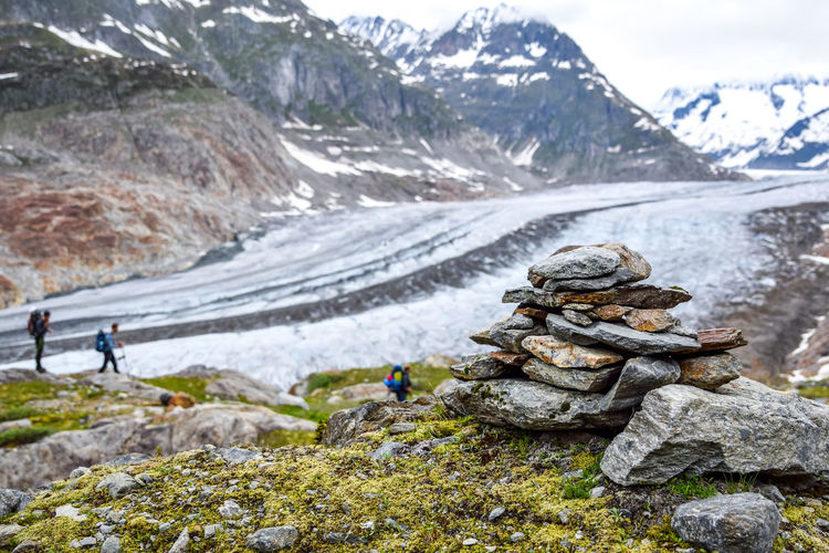 Close-up of stone stack on field against glacier