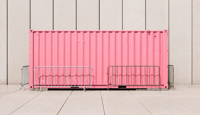 Cargo container against wall