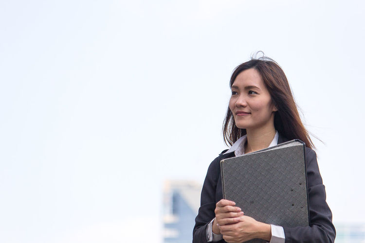 Businesswoman looking away while holding file