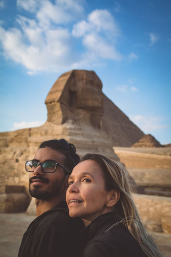 Couple looking away against the sphinx and sky