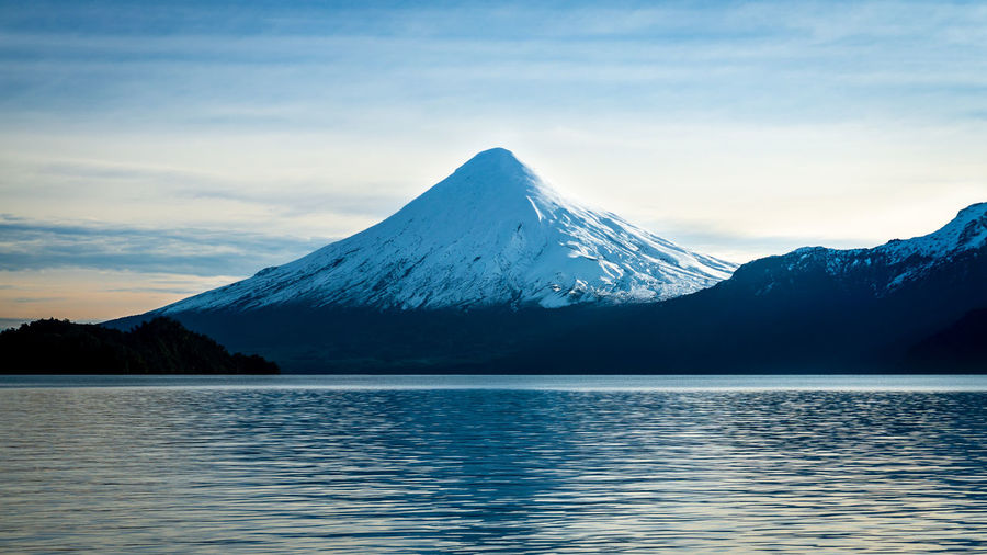 Scenic view of lake and snowcapped mountains against sky - osorno volcan, chile 