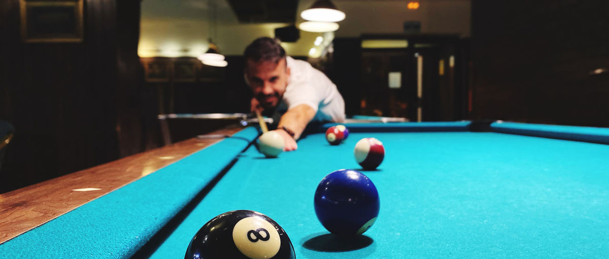 Smiling man playing pool