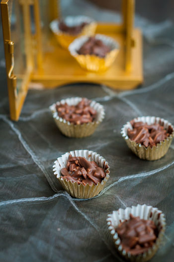 Chocolate covered almonds in golden paper cups.