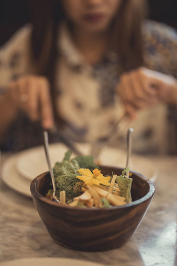 Close-up of woman holding salad in bowl