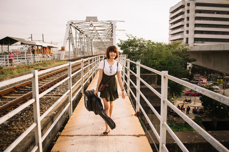 Full length of young woman walking on railroad track