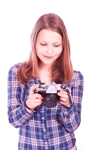 Young woman photographing against white background