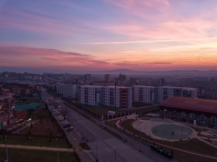 High angle view of road by buildings against sky during sunset
