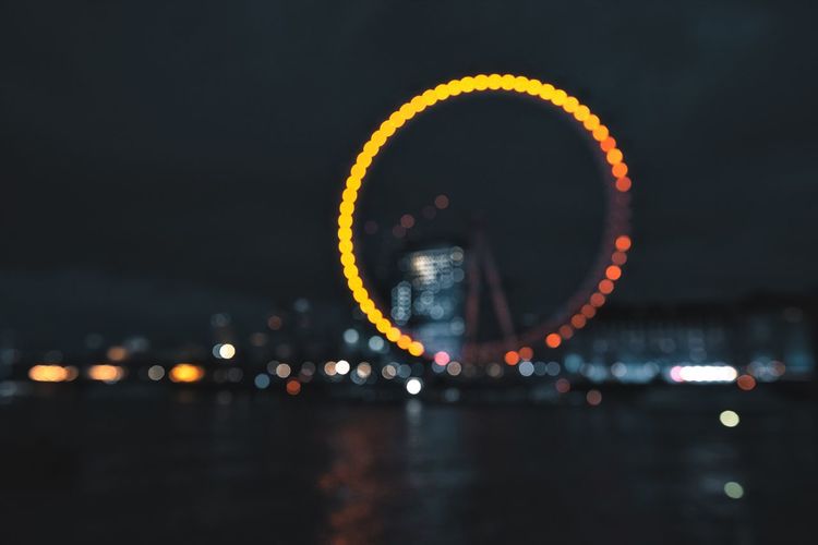 View of illuminated ferris wheel in city at night
