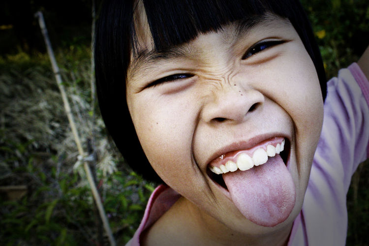 Close-up portrait of girl sticking out tongue
